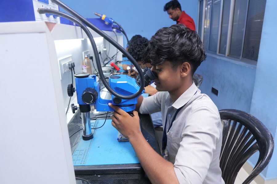 Student using a stereo microscope for chip-level rework