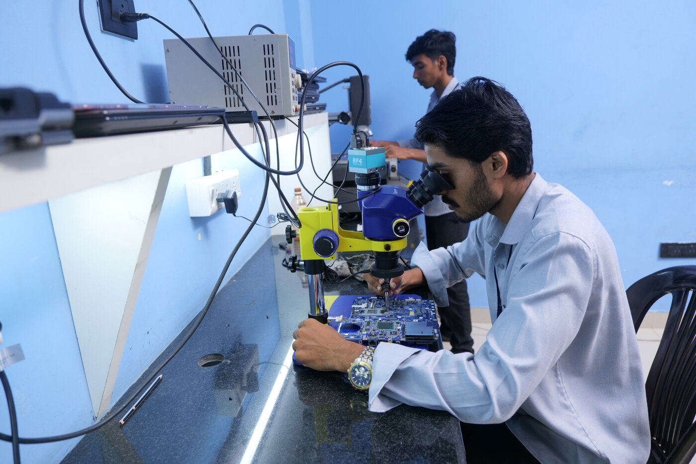 ETC students at a chip-level rework station under a microscope